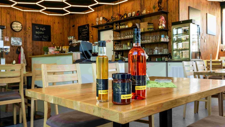 Bee Bar Innenbereich mit Honigprodukten, © Robert Herbst Innenansicht einer Bar mit Honigprodukten auf einem Tisch und wabenförmiger Beleuchtung an der Decke.