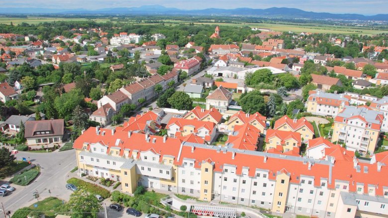 Himberg, © Himberg Luftaufnahme von Himberg mit roten Dächern und grüner Landschaft.