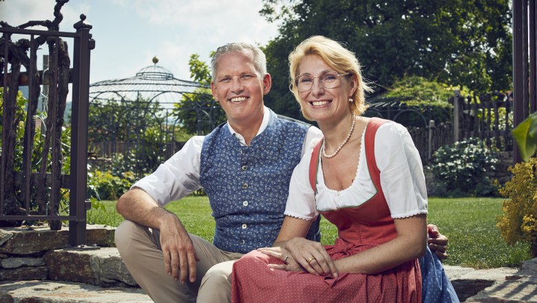 Manuela und Christian Wildeis, © Niederösterreich Werbung/Andreas Hofer Familie Wildeis in Trachtenkleidung sitzen lächelnd im Garten.