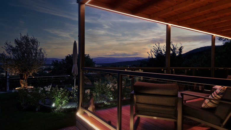Panorama Johannesbachklamm Chalet, © Johannesbachklamm Chalet Abendstimmung auf einer Terrasse mit Blick auf die Berge und einen Garten.