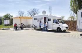 Reisemobilstellplatz Langenlois, © POV, Robert Herbst Reisemobilstellplatz mit Wohnmobil und Personen, die sich unterhalten.