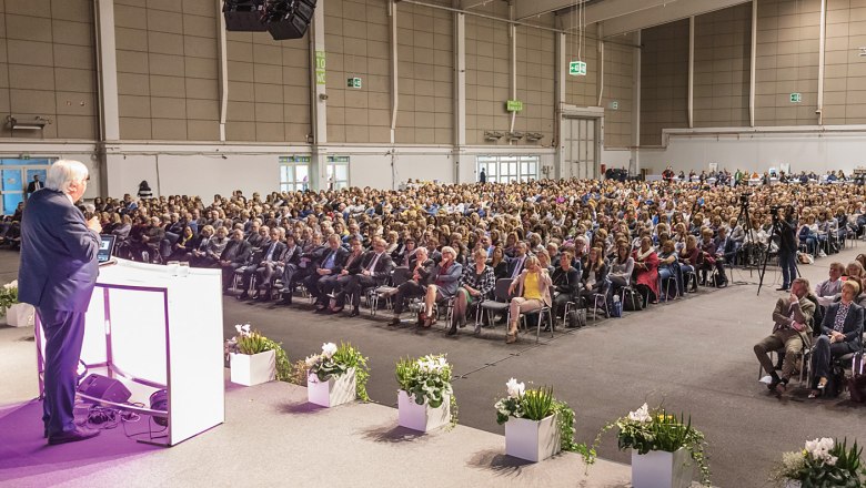 MESSE TULLN, © Messe Tulln/ Friedrich Jansenberger Ein Redner spricht vor einem großen Publikum in einer Messehalle.