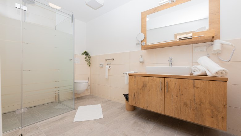 Badezimmer, © Schönfelderhof Modernes Badezimmer mit Dusche, Waschbecken und Toilette.