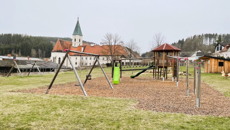 Spielplatz, © Marktgemeinde Schönbach Spielplatz mit Kirche im Hintergrund in Schönbach