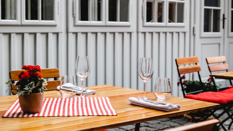 Gastgarten für Sommertage, © Niederösterreich Werbung/David Schreiber Gedeckter Holztisch im Freien mit Blumen und Gläsern.