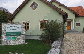 Gästezimmer Rieder, © Fam. Rieder Grünes Haus mit Schild 'Gästezimmer Rieder' im Vorgarten.