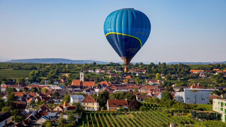 Ballontage Krems-Langenlois 2019 - Ballonfahrt über Langenlois, © Jürgen Übl Heißluftballon über einer Stadtlandschaft mit Weinbergen und Häusern.
