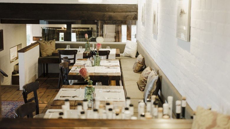 Zeitloses Ambiente zum Wohlfühlen, © Niederösterreich Werbung/Michael Reidinger Gemütliches Restaurant mit Holztischen, Kissen und dezenter Beleuchtung.