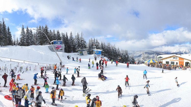 Bergstation Zauberberg Semmering, © Zauberberg Semmering, Foto: Philip Wiedhofer Skigebiet mit vielen Menschen, Sessellift und Berglandschaft.