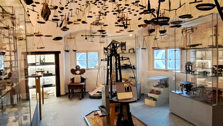 Österreichisches Waagenmuseum im ÖLM, © Schloss Leiben GmbH Innenansicht des Österreichischen Waagenmuseums mit zahlreichen Waagen an der Decke und in Vitrinen.