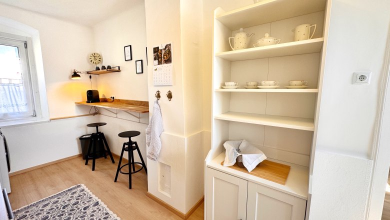 Küche, © Christoph Menhofer Helle Küche mit Regal, Barhockern und Kaffeemaschine.