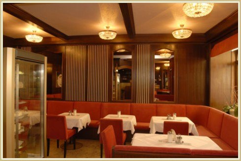 Restaurant "Zum Fürsten" Innenansicht, © Restaurant "Zum Fürsten" Innenansicht eines eleganten Restaurants mit roten Sitzbänken und weißen Tischdecken.