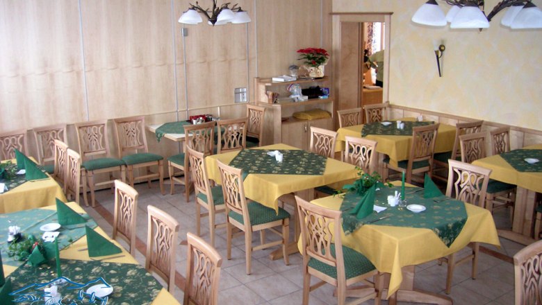 Florian's Teichstüberl - Gaststube, © Teichstüberl Innenansicht eines Restaurants mit Holzmöbeln und gelb-grünen Tischdecken.
