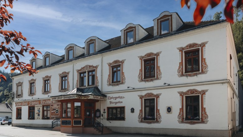 Spezialitäten-Wirtshaus mit Wildtagen oder Fischwochen, © Niederösterreich Werbung/David Schreiber Historisches Gebäude mit dekorativen Fensterrahmen und Schildern für Hotel und Restaurant.