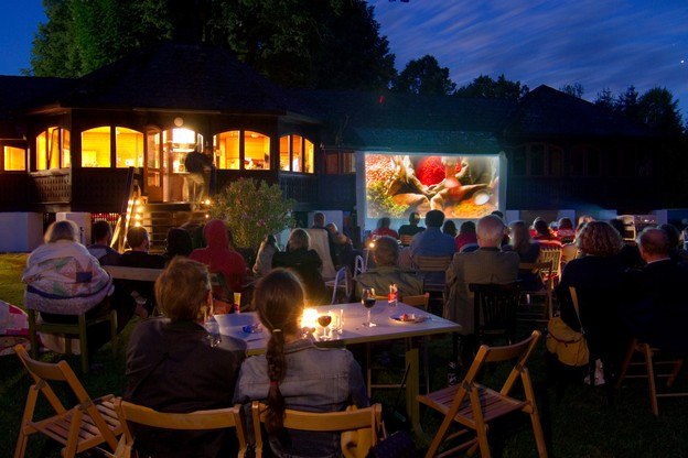 Filmclub Drosendorf, © Filmclub Drosendorf Menschen schauen im Freien einen Film auf einer Leinwand an.