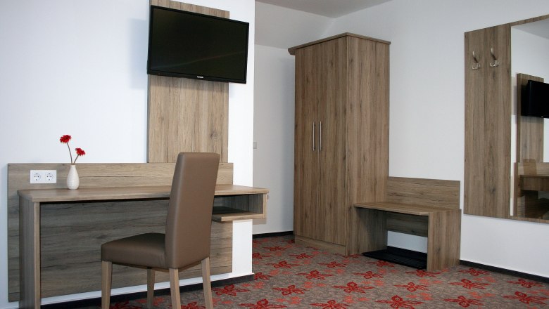 Doppelzimmer, © Gerhard Auer Hotelzimmer mit Schreibtisch, Stuhl, Fernseher und Schrank.
