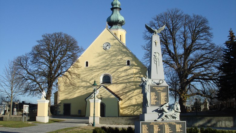 Pfarrkirche des heiligen Hippolyt, © Gemeinde Harmannsdorf-Rückersdorf Pfarrkirche des heiligen Hippolyt mit Kriegerdenkmal im Vordergrund.