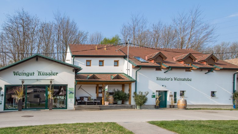 Winzerhof Küssler, © Winzerhof Küssler Weingut Küssler mit Weinbar und Terrasse, umgeben von Bäumen.