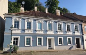 Alte Post Greifenstein, © Eduard Renfer Blaues historisches Gebäude mit weißen Fensterrahmen und Ziegeldach.
