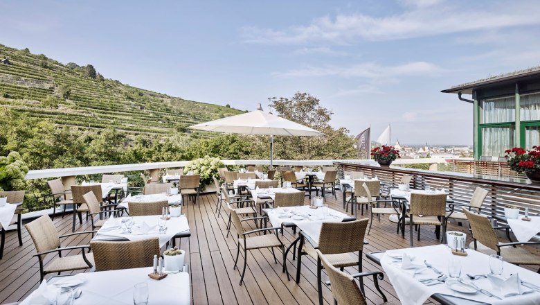 Restaurant Terrasse, © Steigenberger Hotel and Spa, Gregor Titze Restaurantterrasse mit gedeckten Tischen und Blick auf die Weinberge.