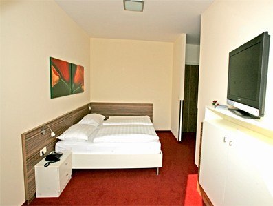 Zimmer Gh zur Wachau, © Familie Zeller Hotelzimmer mit Doppelbett, rotem Teppich und Wandbild.