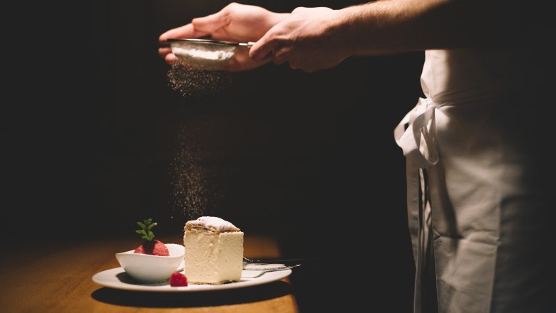 Wenn Cremeschnitte auf Himbeersorbet trifft… mmmh…., © Niederösterreich Werbung/Mara Hohla Ein Teller mit Cremeschnitte und Himbeersorbet, darüber wird Puderzucker gestreut.