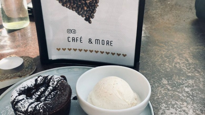 Cafe Herzstück, © Cafe Herzstück_Stephanie Kirschner Ein Dessertteller mit Schokoladenkuchen, Vanilleeis und Johannisbeeren neben einem Herzstück-Menü.