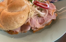 TD-Alpenvereinshaus Tulln-Belegtes Weckerl-c-Birgit Rabacher (1), © Birgit Rabacher Ein belegtes Brötchen mit Schinken, Zwiebeln und Paprika auf einem Teller.