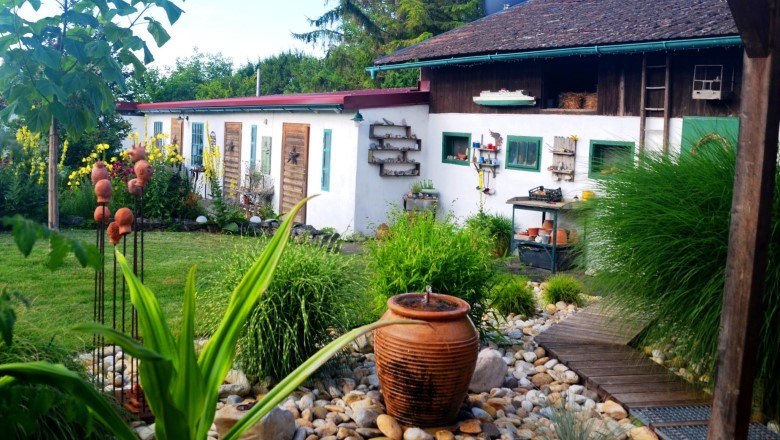 keramikwerkstatt_klein_farbe_c_familie-mahr, © Familie Mahr Ein idyllischer Garten mit Keramikdekorationen und einem weißen Gebäude im Hintergrund.