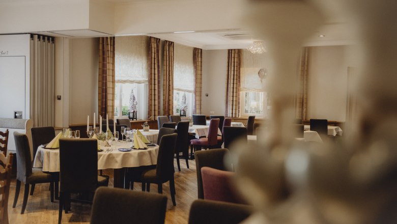 Stilvolles Ambiente mit Platz für Feste, © Niederösterreich Werbung/Rita Newman Eleganter Speisesaal mit gedeckten Tischen und Kerzen.