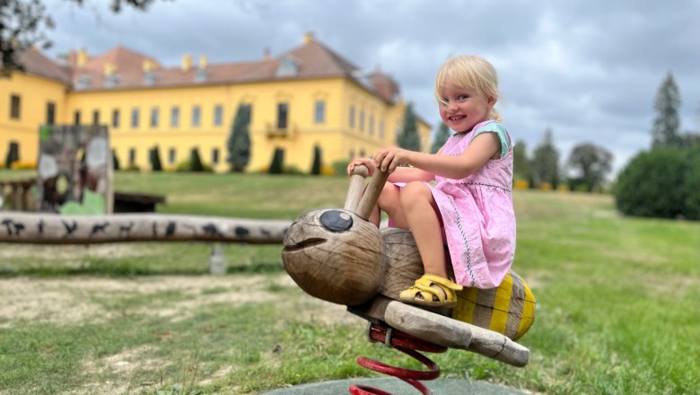 Schloss Eckartsau ÖBf Archiv_Lepizh (2), © ÖBf Archiv_Lepizh Ein Kind auf einem Spielplatz vor Schloss Eckartsau.