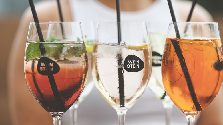 WeinStein im Glas, © Michael Reidinger Nahaufnahme von Weingläsern mit verschiedenen Getränken und Strohhalmen.