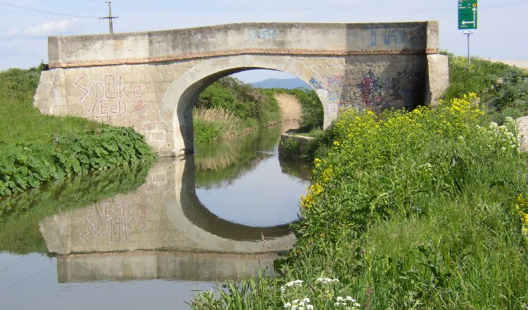 Wiener Neustädter Kanal in Eggendorf, © Wolfgang Glock Brücke über den Wiener Neustädter Kanal in Eggendorf mit Graffiti und Spiegelung im Wasser.