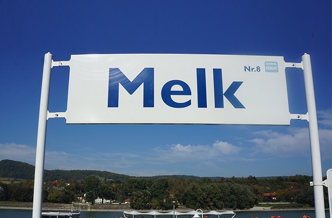 Anlegesteg in Melk Donaustation Nr. 8, © Donau Schiffsstationen GmbH Schild mit der Aufschrift 'Melk Nr. 8' vor blauem Himmel.