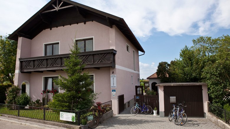 Gästehaus Schlossblick, © Marschik Straßenansicht des Hauses mit gepflegtem Vorgarten und Einfahrt mit Garage.