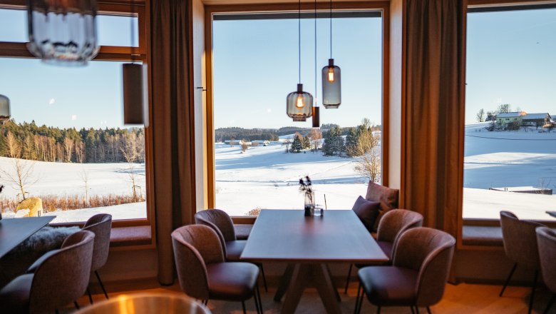 Modernes Restaurant mit Waldviertler Weitblick, © Niederösterreich Werbung/Daniel Gollner Innenansicht eines modernen Restaurants mit großen Fenstern und Blick auf eine verschneite Landschaft.