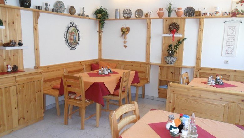 Pension Hendling, © Josef Hendling Gemütlicher Frühstücksraum mit Holzmöbeln und Dekorationen an den Wänden.