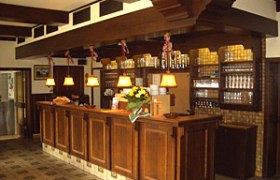 Gasthof Kögl 'Zum Liederfürst', © Gasthof Kögl Holztheke in einem traditionellen Gasthof mit Lampen und Gläsern.