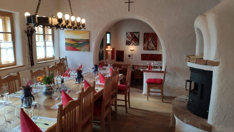 Verkostung, © Bio-Weinbau Killmeyer Gemütlicher Raum mit gedecktem Tisch, Weingläsern und Kamin.