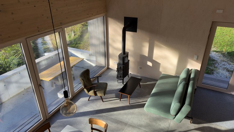 Wohn-/Essbereich, © Meinrad Hofer Moderner Wohn- und Essbereich mit großen Fenstern, Sofa, Sessel und Kamin.