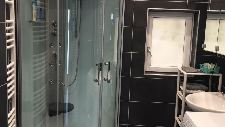 Badezimmer, Ferienwohnung Brandstetter Kathi, Frauenhofen, © Brandstatter-Mszyca Kathi Modernes Badezimmer mit Dusche, Waschmaschine und Waschbecken.