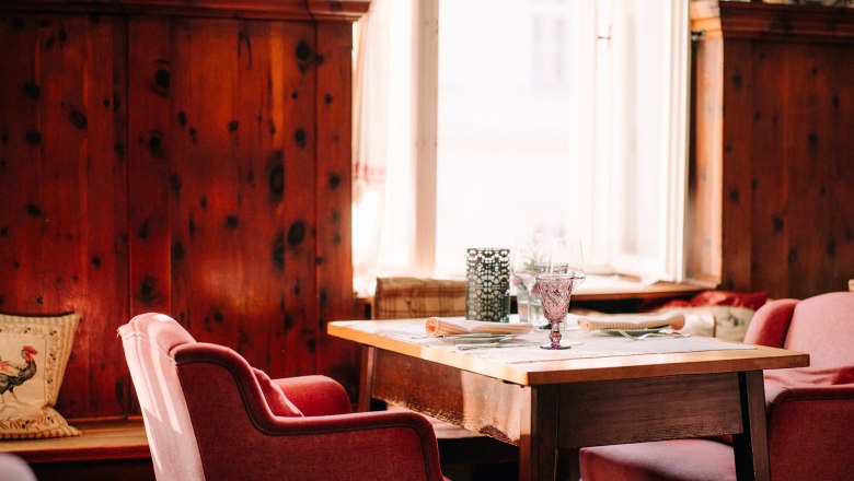 Traditionshaus aus dem 16. Jahrhundert, © Niederösterreich Werbung/Julius Hirtzberger Gemütliche Einrichtung mit Holzwänden und roten Sesseln.