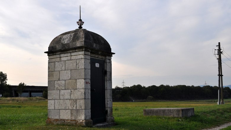 Matzendorf-Hölles, © Spiderman183 Steinbauwerk auf einer Wiese mit Strommast im Hintergrund.