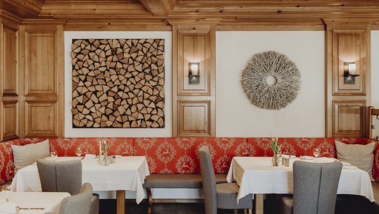 Moderner Restaurantbereich, © Niederösterreich Werbung/Sophie Menegaldo Ein stilvoll eingerichteter Restaurantbereich mit Holzwänden, roten Polstern und dekorativen Wandkunstwerken.