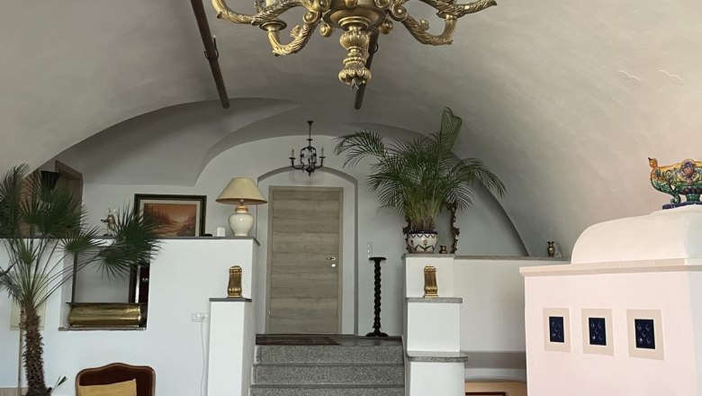 Lounge-Stiege, © Georg Smolka Eleganter Raum mit Kronleuchter, Kamin und Treppe.