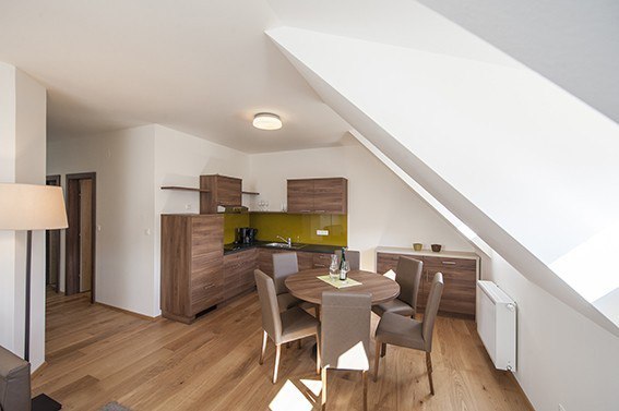 Appartment Weingut Lehensteiner, © Weingut Lehensteiner Modernes Apartment mit Holzboden, Esstisch und Küchenzeile.