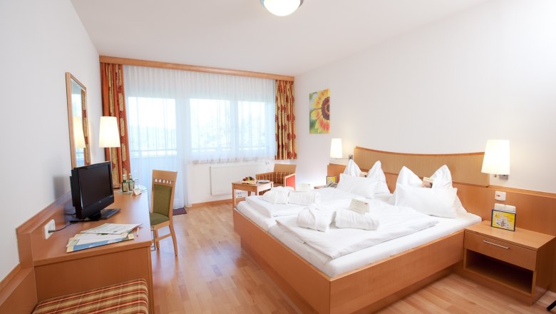 Herz-Kreislauf-Zentrum Groß Gerungs****, © Herz-Kreislauf-Zentrum Groß Gerungs Helles Hotelzimmer mit Doppelbett, Schreibtisch, Fernseher und großen Fenstern.