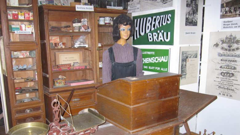 Heimatmuseum Niederleis, © Heimatmuseum Niederleis Historischer Laden im Heimatmuseum Niederleis mit Waage, Schaufensterpuppe und alten Werbeschildern.