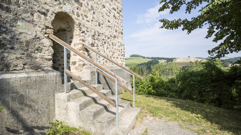 Feuerturm der Burgruine Kirchschlag, © Wiener Alpen, Franz Zwickl Eingang zum Feuerturm der Burgruine Kirchschlag mit Treppe und Landschaft im Hintergrund.