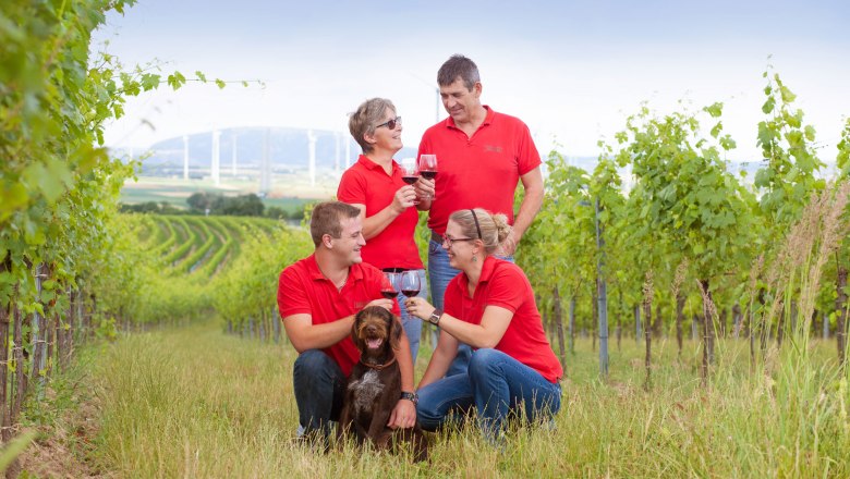BioWeingut Raser-Bayer, Höflein, © Raser-Bayer Vier Personen in roten Hemden und ein Hund in einem Weinberg.
